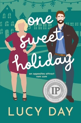 A book cover for "One Sweet Holiday" by Lucy Day. The cover features stylized illustrations of two people against a teal background with white snowflake-like designs at the top and outlines of houses in the middle. On the left is a woman with blonde hair, wearing a pink dress and black heels, with her hands on her hips. On the right is a man with brown hair and a beard, wearing a brown jacket over a blue shirt and brown pants. The title "one sweet holiday" is written in a whimsical script font in white across the center, with the subtitle "an opposites attract rom com" below in smaller font.  At the bottom, the author's name "LUCY DAY" is written in white block letters. A round silver seal with text "Excellence in Independent Publishing" and "IP Book Awards Silver" is visible on the right side.