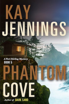 A book cover for "Phantom Cove" by Kay Jennings. The cover features a dramatic landscape with a small wooden cabin perched on a rocky cliff overlooking a foggy, mountainous seascape. The cabin has a warm light emanating from its window. The title, "PHANTOM COVE," is prominently displayed in bold, stylized letters, with "KAY JENNINGS" above it in a smaller, but still bold font. Below the title, it reads "A Port Stirling Mystery Book 5" and "Author of DARK SAND." The overall color palette is dark and moody, with blues, grays, and a touch of orange from the sunset in the background. The image evokes a sense of mystery and suspense.
