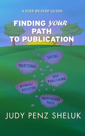 A book cover for "Finding Your Path to Publication" by Judy Penz Sheluk. The cover features a whimsical illustration of a green rolling hill with five purple stepping stones leading up the hill. Each stepping stone is labeled with a different publishing option: "Traditional," "Hybrid/Assisted," "Social," "Self-Publishing," and "Independent Press." Two stylized green trees stand at the top of the hill. The title "FINDING YOUR PATH TO PUBLICATION" is written in bold, white letters across the center of the hill. The author's name, "JUDY PENZ SHELUK," is at the bottom in bold, white letters. At the very top, in smaller white letters, it reads "- A STEP-BY-STEP GUIDE -". The overall color palette is bright and cheerful, with greens, purples, and white.